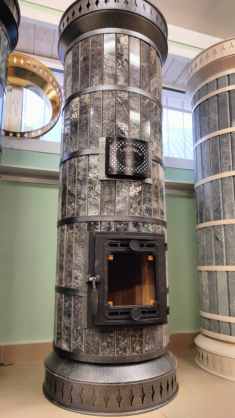 A Tundra model masonry heater featuring premium Amphibolite black stone cladding with a natural speckled texture.