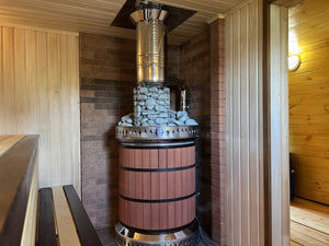 Red brick masonry sauna masonry heater installed in a corner with a matching red brick heat shield wall