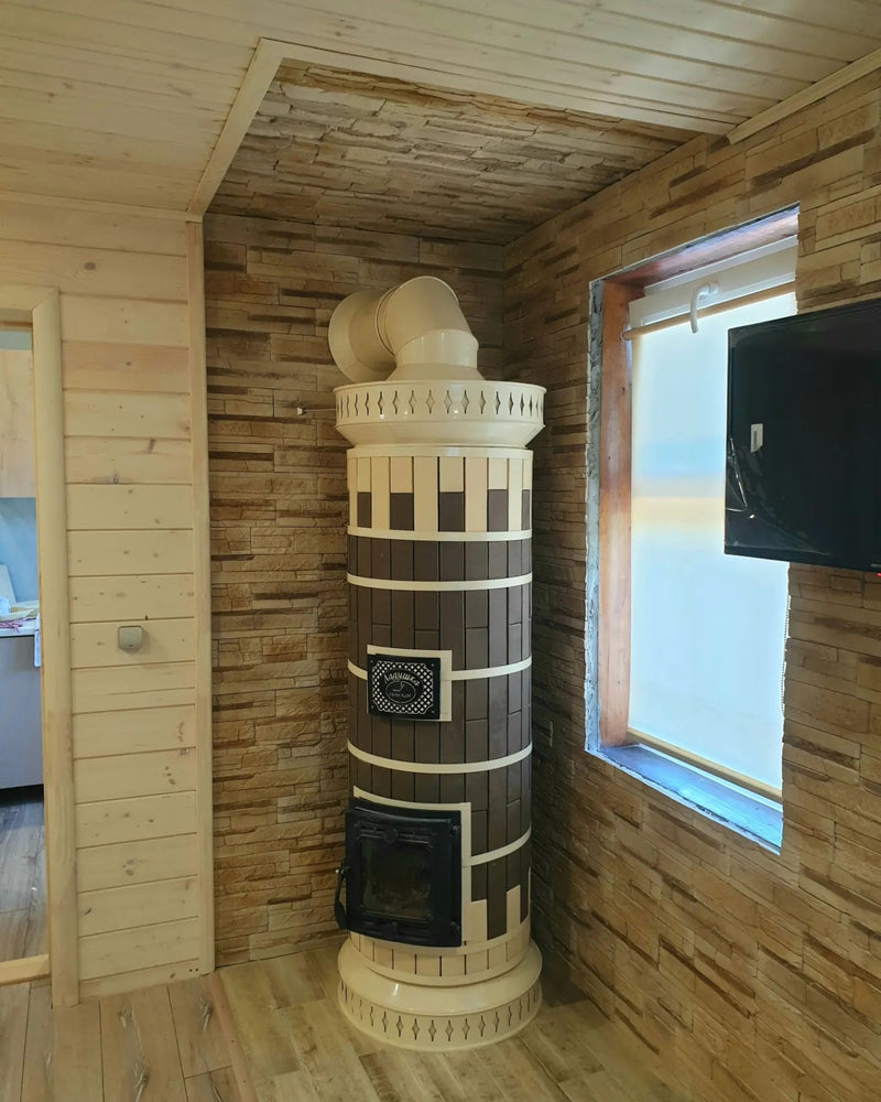 A Tundra model masonry heater featuring a two-tone brown and cream finish, installed in a corner with textured stone veneer walls.