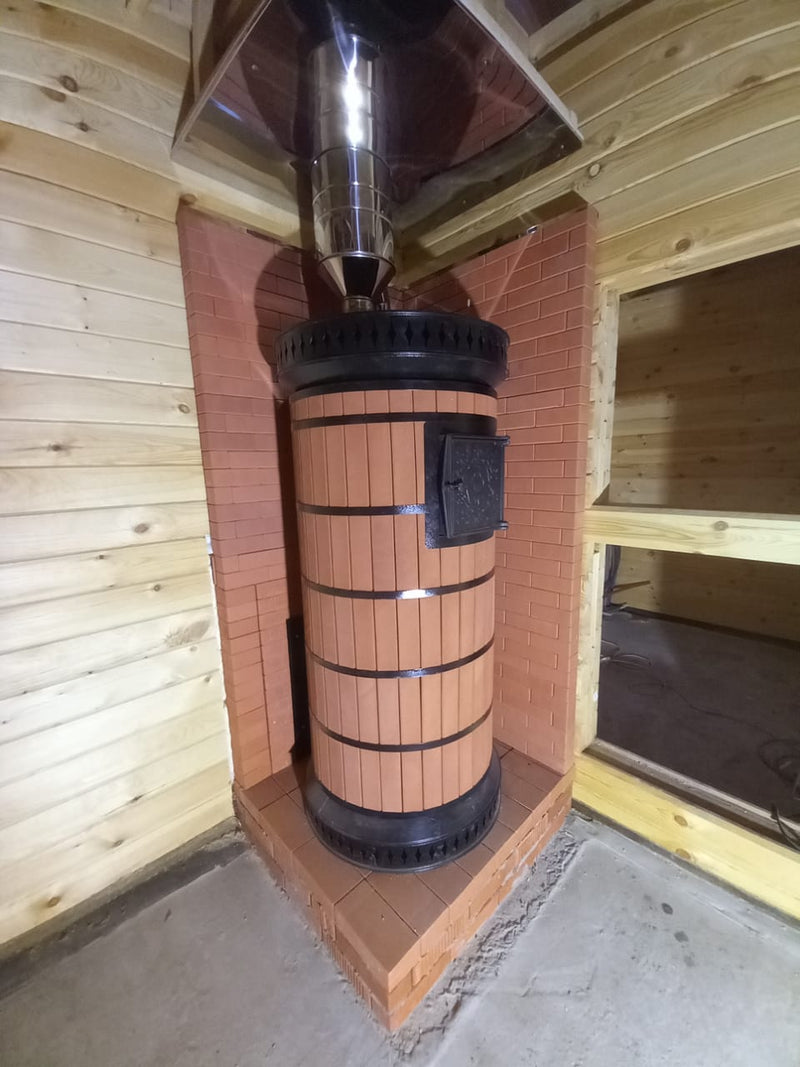 Red brick masonry heater installed in a tight corner with brick heat shield protection for wooden walls
