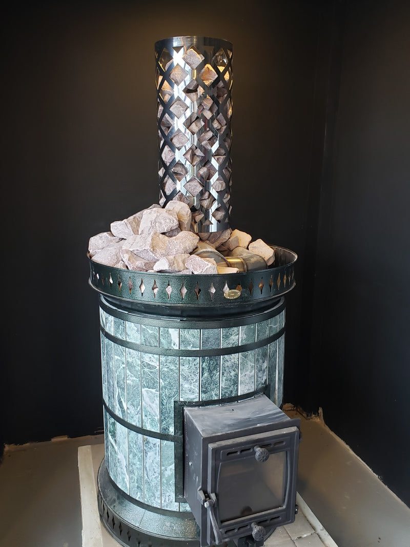 Green serpentine sauna heater topped with contrasting white quartz sauna stones