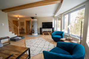 A luxurious living room featuring a Siberia blue soapstone stone masonry heater with white decorative trim.