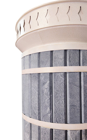 Close up of rough-cut natural blue soapstone stone texture and decorative cream metal trim on masonry heater