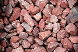 Pile of raw rose quartzite sauna stones used for thermal mass and steam generation.