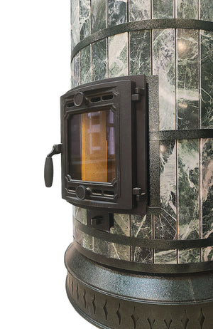 Side profile close-up of the Siberia masonry heater, showcasing the natural green serpentine stone cladding (jade style) and cast iron hardware.
